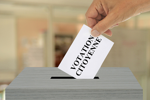 French citizen voting concept with a ballot slipped into a ballot box closeup