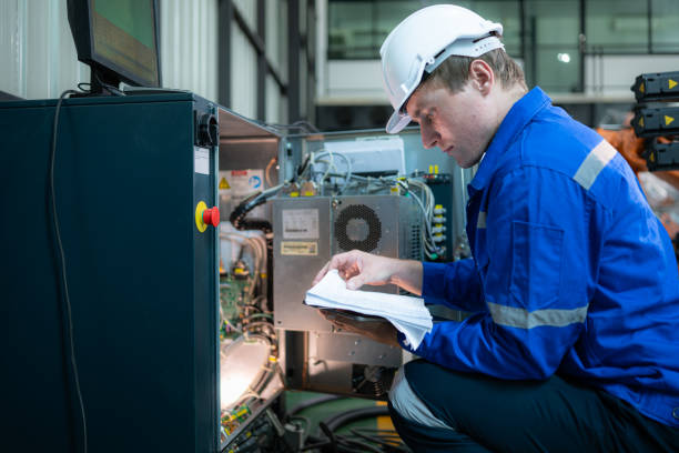 istock Technician working on the electrical control cabinet of robotic arm 1954986851