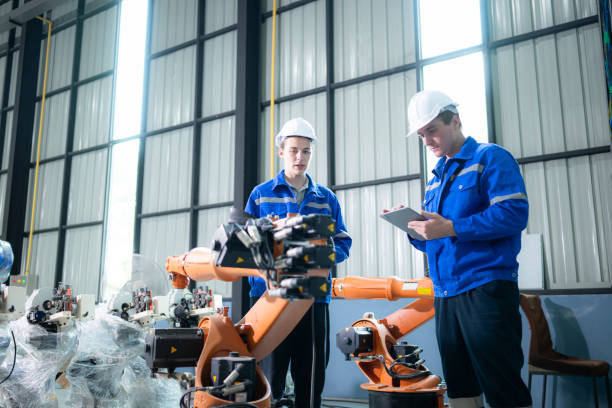 istock Engineer and technician working with robot arm in factory. Industry and engineering concept. 1954986853