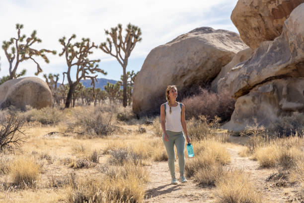 istock Lone Wanderer: A Woman's Solo Hike with Water in Hand 1954988959