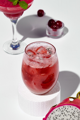 An exotic lemonade with pitaya fruit, staged on a white pedestal against a contrasting blue and white background.