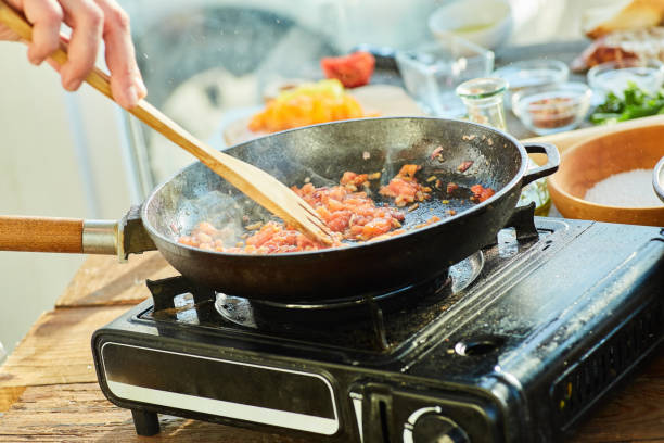 istock Step-by-step cooking process. Fry the chopped tomatoes together with onions in a preheated frying pan 1955017187