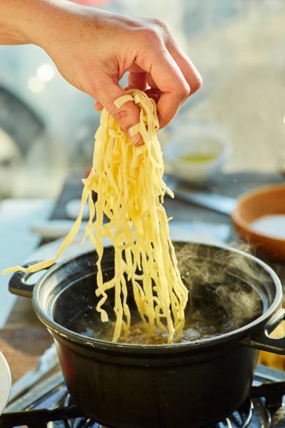 istock Step-by-step cooking process. Tossed raw noodles into a pot of boiling water 1955017656