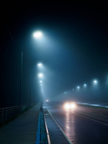 istock foggy night road, light from car headlights 1955019381