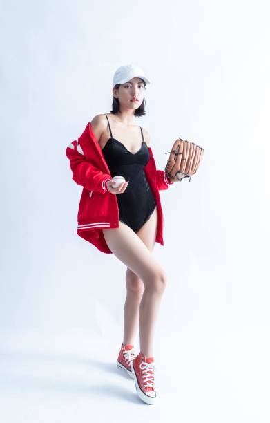 femme asiatique en blouson aviateur rouge et body noir tenant une balle de baseball et un gant - joueur de champ gauche photos et images de collection