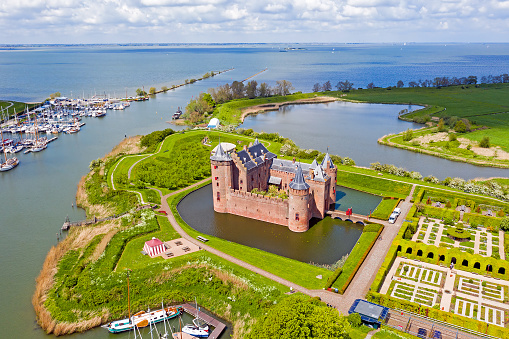 Muiden, Netherlands - 05/25/2021: Aerial from the medieval Muiderslot castle at the IJsselmeer in the Netherlands