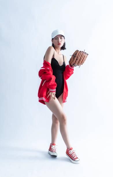 빨간 폭격기 재킷과 흰색 모자를 쓴 아시아 여성이 야구 글러브를 끼고 포즈를 취하고 있다 - centerfielder 뉴스 사진 이미지