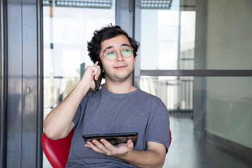 Young man with glasses working with his tablet in the office