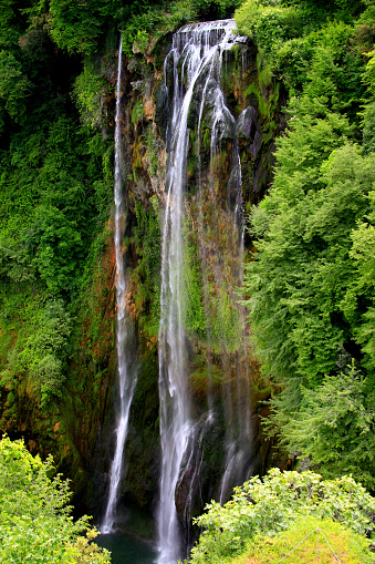 Landscape view of the vertical part of Cascata delle Marmore waterfall the waters of which fall from a high rock surrounded by greenery