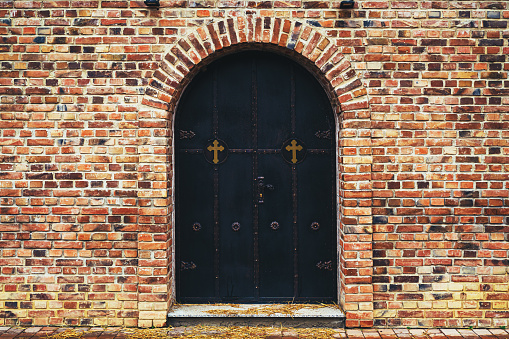 Serbian orthodox church entrance door with vintage ornament decoration surrounded by clinker brick wall with copy space