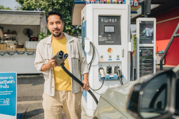 istock Mature man use electric vehicle charging station system, modern automobile technology Bangkok, Thailand 1955194463