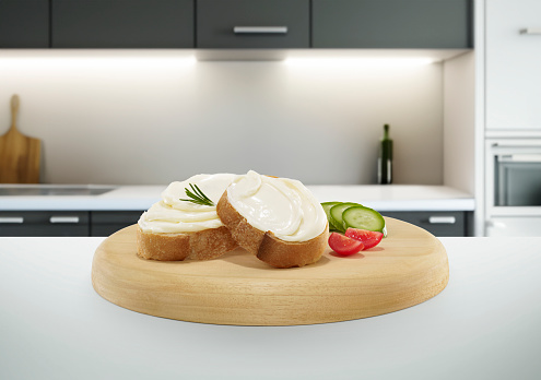 Sliced breads with cream cheese spread on a kitchen island inside of a domestic kitchen