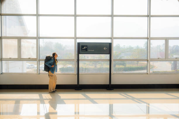 Woman walking in the airport with backpack waiting for boarding