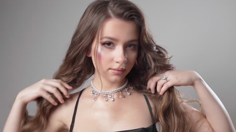 The girl shows off an expensive beautiful necklace made of diamonds and pearls.