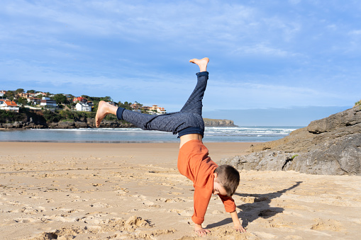 Boy doing cartwheel on a beach