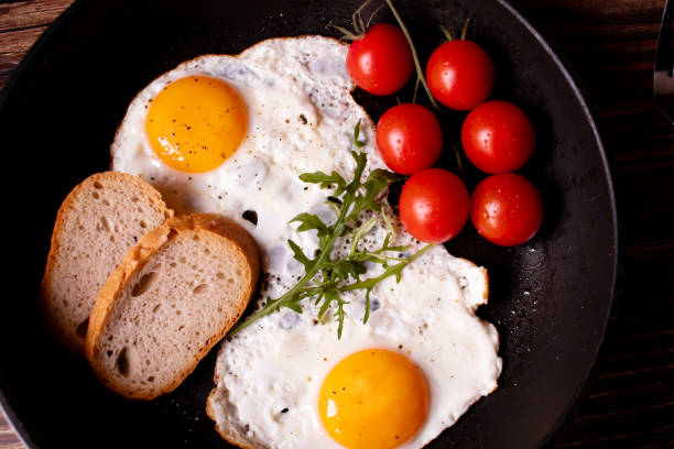 istock Fried eggs in a pan. on a wooden background. Breakfast 1955300422
