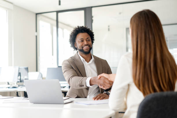 istock A warm handshake between a man and a woman in a contemporary office 1955305722