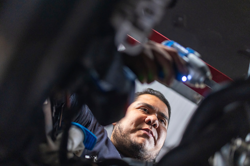 Portrait of mechanic examining engine
