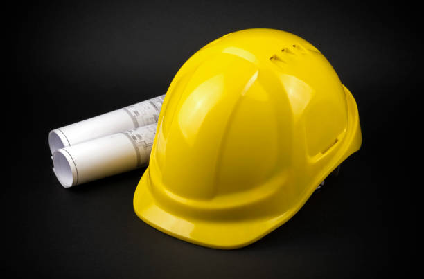 istock Yellow safety hard hat with engineering drawings 1955351954