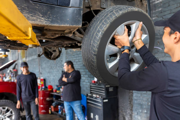 istock Young mechanic fitting a new tyre on a car 1955353606
