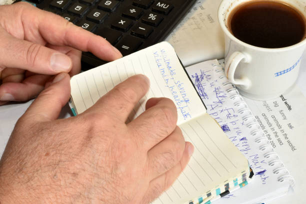 istock At his desk in the office, a man flips through a notepad. 1955365241