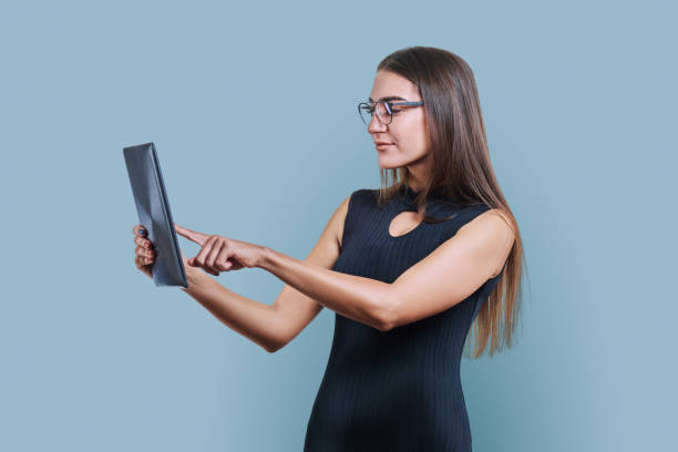 istock Young business woman with digital tablet on gray studio background 1955367868