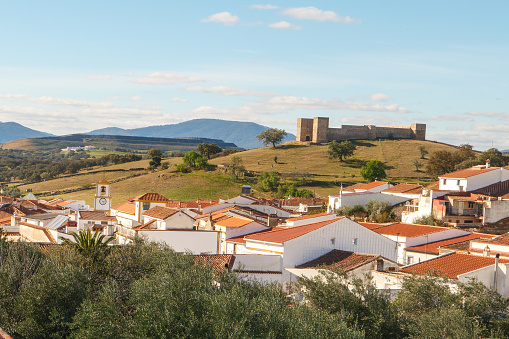 A view over the rooftops of El Real de la Jara, province of Seville, Andalusia in Spain with the castle in the background on the Camino Via de la Plata pilgrimage route to Santiago