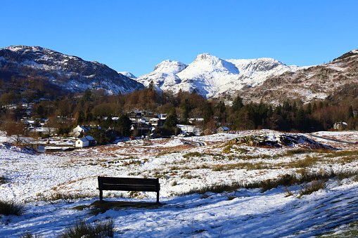Winter View of Elterwater and the Langdale Valley. Beautiful clear blue sky and a carpet of snow. A seat to relax and take in the landscape.