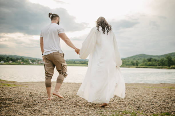 Happy young couple walking by the lake outdoors.