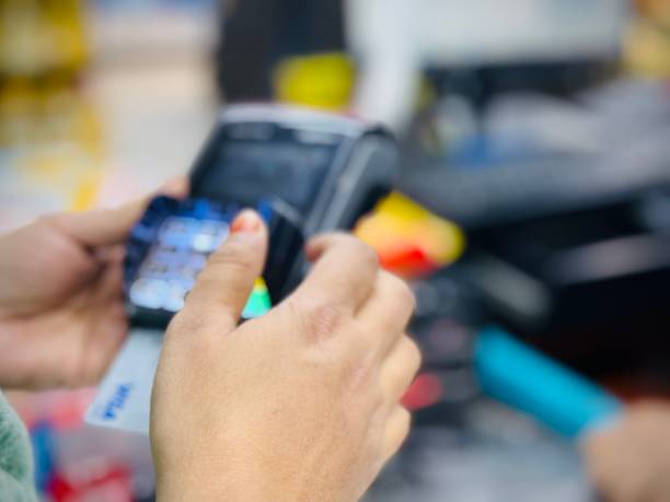 istock Young woman making payment for superstore with pos terminal. 1955438067