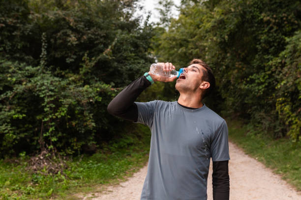 istock Hydration Break: A Jogger Refreshing with a Water Bottle on a Forest Trail 1955448872