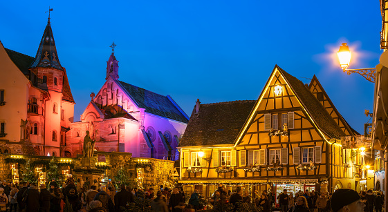 Eguisheim, France - December 23, 2023: Traditional Christmas market in medieval town of Eguisheim in Alsace along the wine road - blue hour