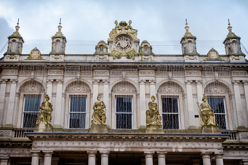 Part of the former main Post Office on Cornhill in Ipswich, Suffolk, Eastern England. The facade is decorated with Christmas lights. The statues on the portico represent Industry, Electricity, Steam and Commerce.