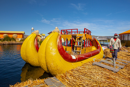 Uros, Peru - April 29, 2022: Traditional reed boat as transportation for tourists, Islas es los Uros, Lake Titicaca, Peru