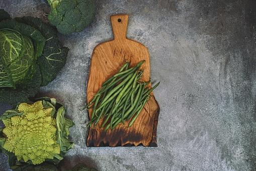 Low glycemic health food for diabetics with vegetables, dips & pasta with all foods below 55 on the GI index. High in antioxidants, vitamins, minerals, protein, smart carbs. Flat lay on mottled grey.