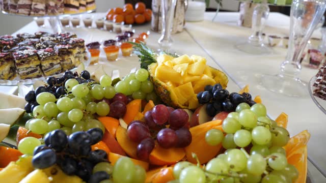 Fruit buffet. Grapes, pineapples, oranges, apples and others. Slow motion.