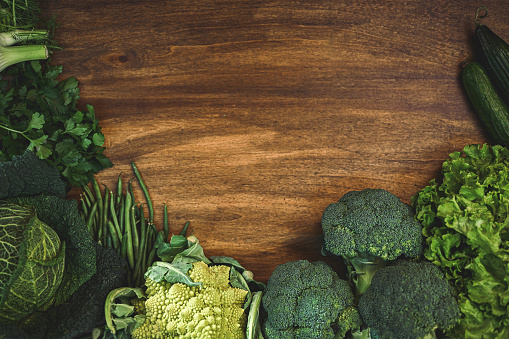 raw green vegetables on a wooden table.