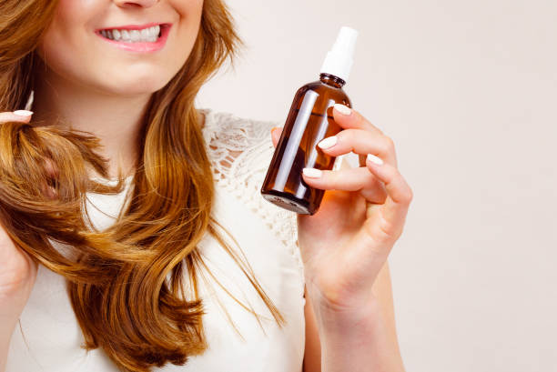 istock Woman applying hair cosmetic 1955485586