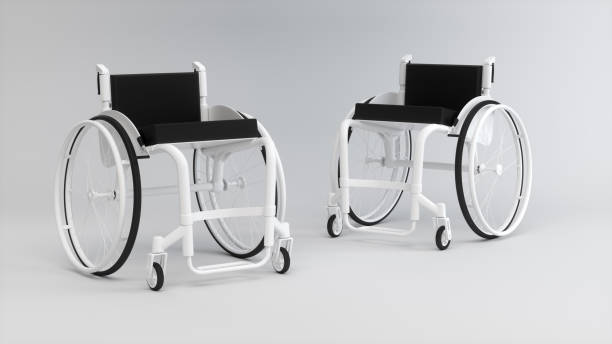 istock Two White Wheelchairs Opposite Each Other on a Soft Gray Studio Background. Medicine concept. Monochrome. 1955510891