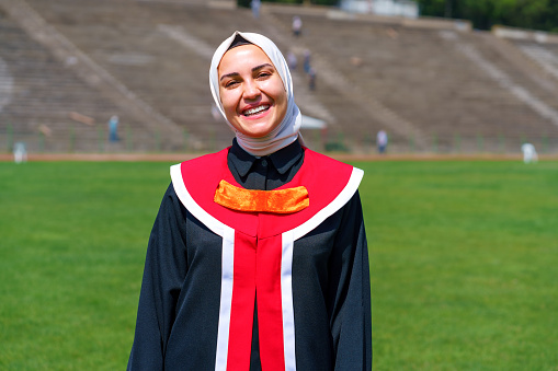 Portrait of Young Hijab Women in Graduation Gown and looking  at the camera