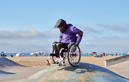 disable athlete man in wheelchair perform tricks in skatepark