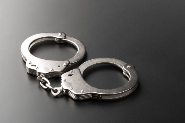 istock Police handcuffs on dark background with copy space 1955575441