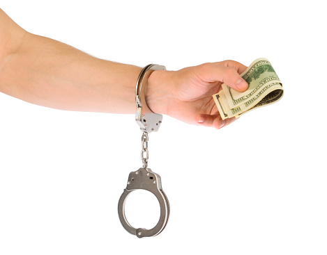 Arrest,  man's hand holding money in handcuffs. isolated with clipping path