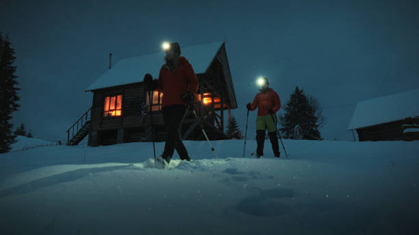 istock Young couple hike through snow at night 1955583241