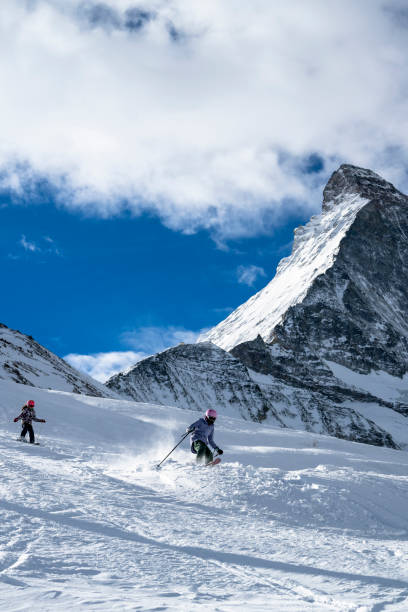 istock Girls ski down slope at ski resort 1955602194