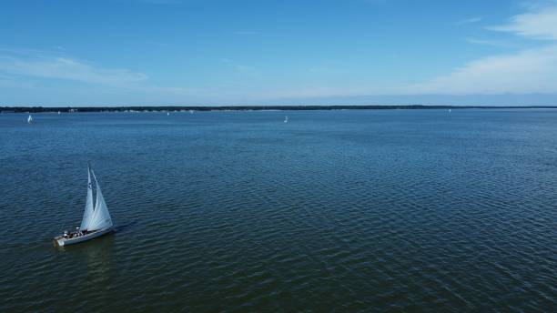 istock Serene sailboat gracefully glides across tranquil waters beneath an elegant bridge 1955651391