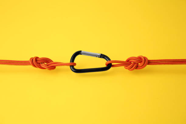 istock One metal carabiner with ropes on yellow background 1955658272