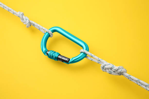 istock One metal carabiner with ropes on yellow background 1955658310