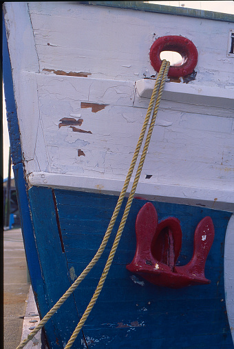 A wooden fishing boat is tied to the dock with rope after a day on the sea in Alaska.