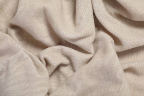 istock Texture of beige blanket as background, top view 1955675307